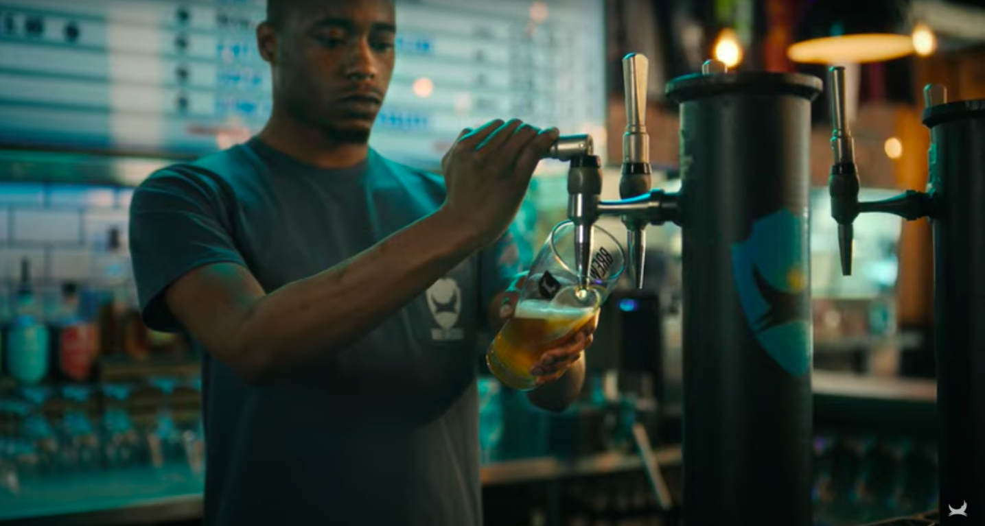 BrewDog employee pouring a pint: BrewDog launches 'Beer for All' carbon negative ad campaign