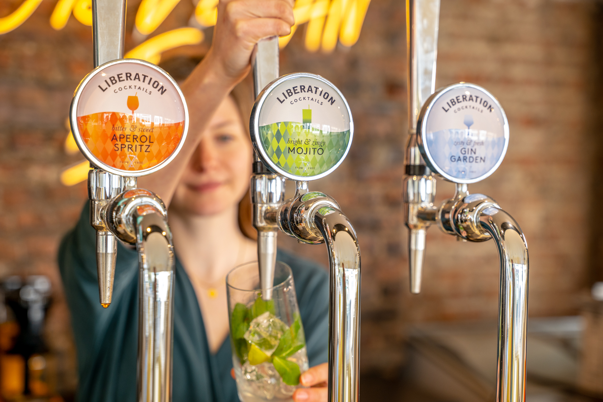 Woman pours an on-tap cocktail: on-tap cocktails are the next trend for festival-goers to enjoy