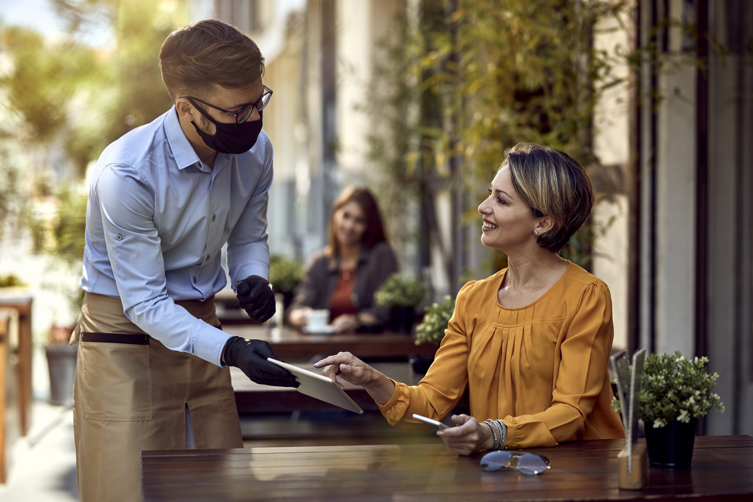 waiter serving woman: hospitality in crisis with staggering number of roles unfilled