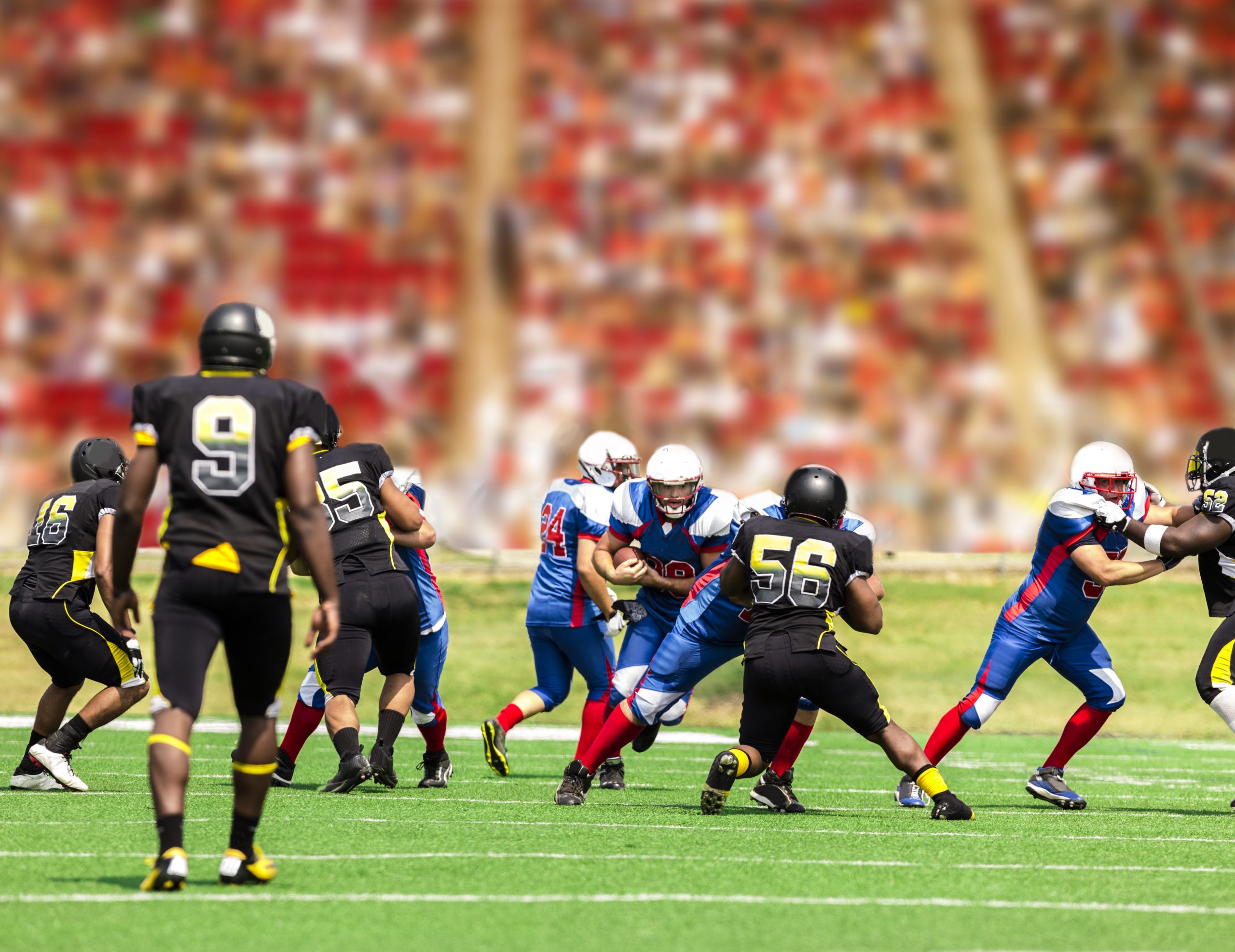 american football players on a pitch: College football player suspended after chugging a beer on moving bus