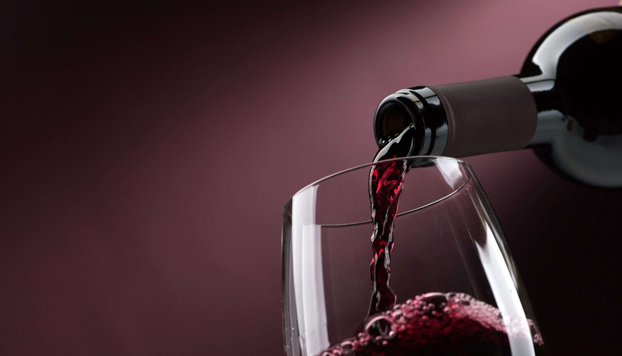 red wine poured bottle to glass: fine wine sales boosted by pandemic, research reveals