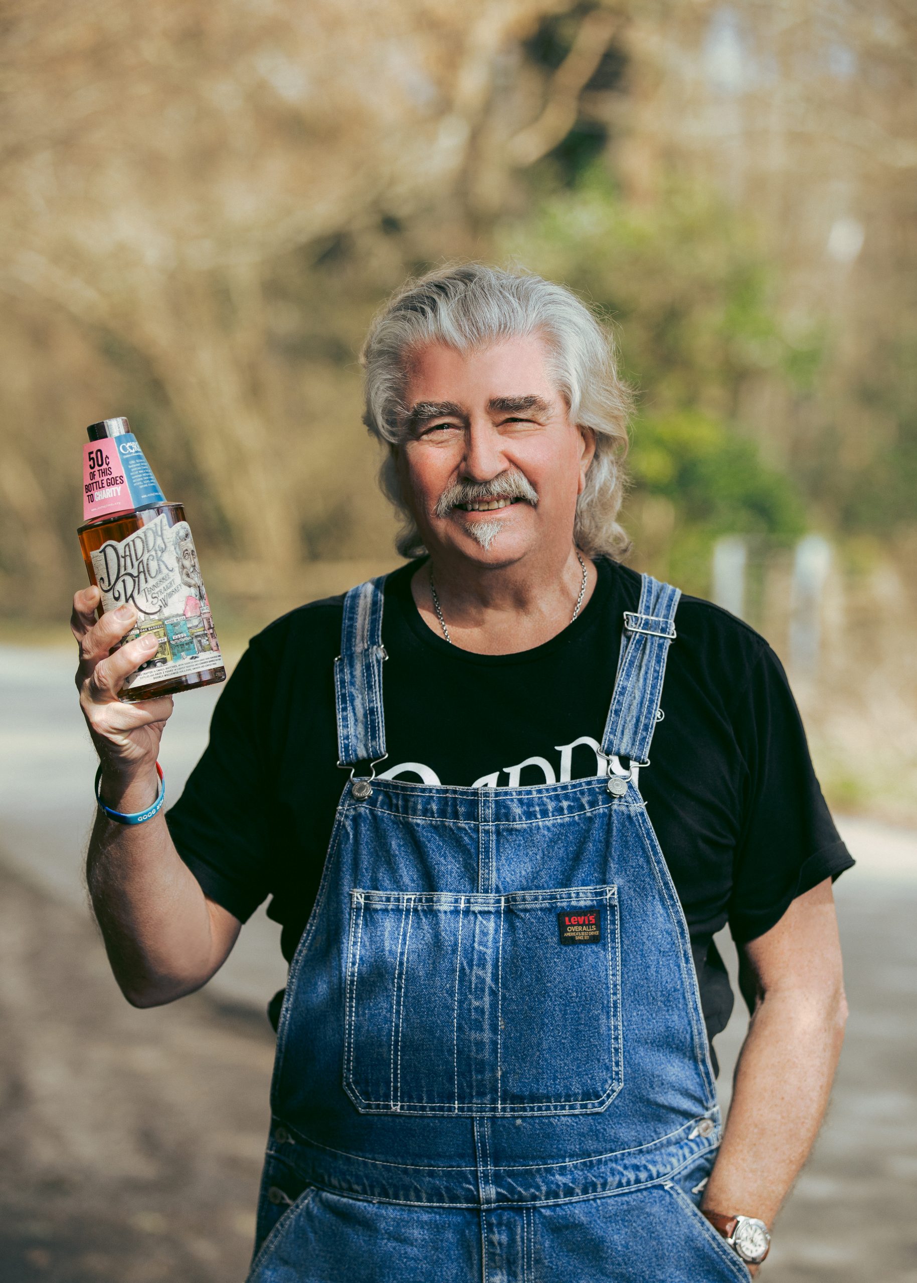 James 'Daddy Rack' Rackham holding bottle of spirit: Daddy Rack whiskey becomes the first of its kind to launch in Waitrose