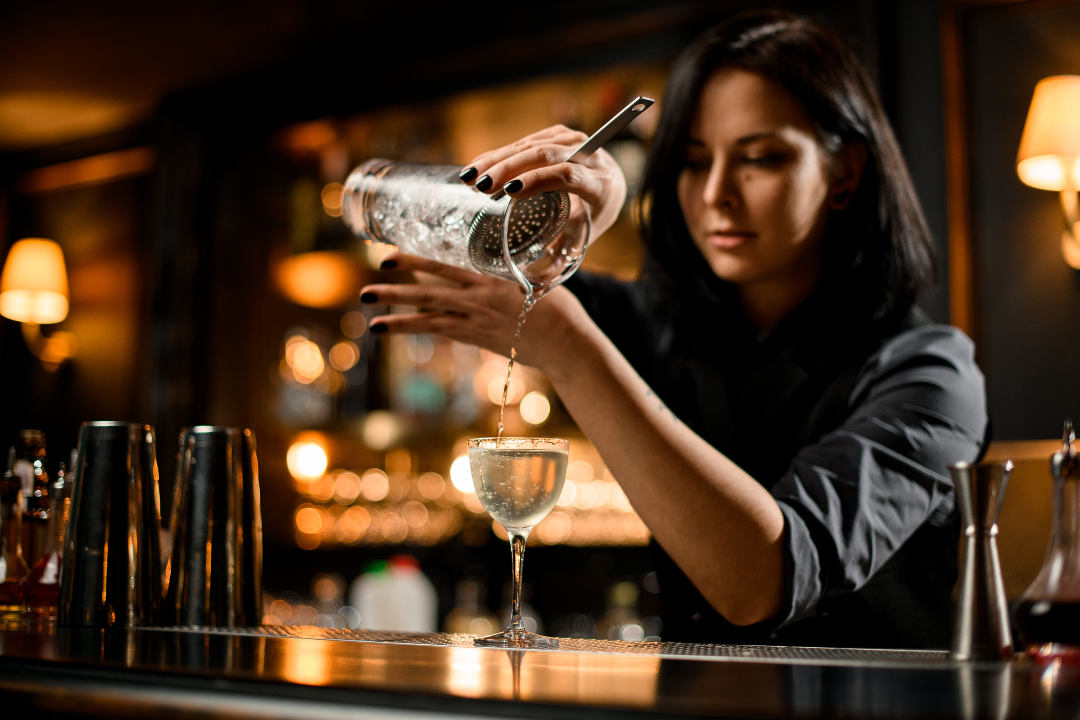 bartender tips: a female bartender pouring a drink