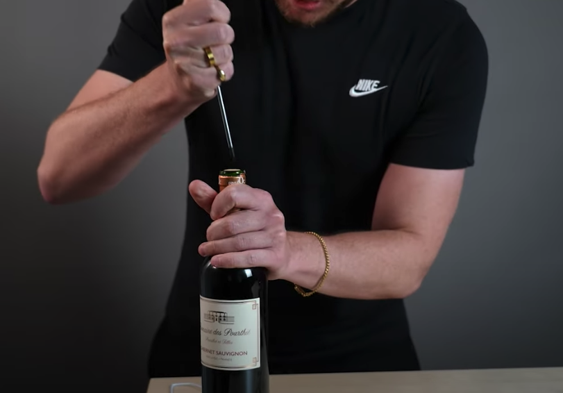 How do you open a bottle of wine with no corkscrew?