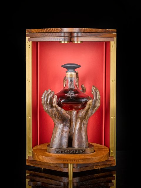 Image of The Macallan Reach bottle in bronze hand stand: Wine and spirits auction sales at Sotheby's hit record $150 million in 2022