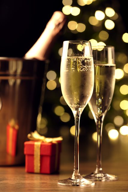 Glasses of Champagne next to small present: Rising demand for Bordeaux and Champagne ahead of Christmas