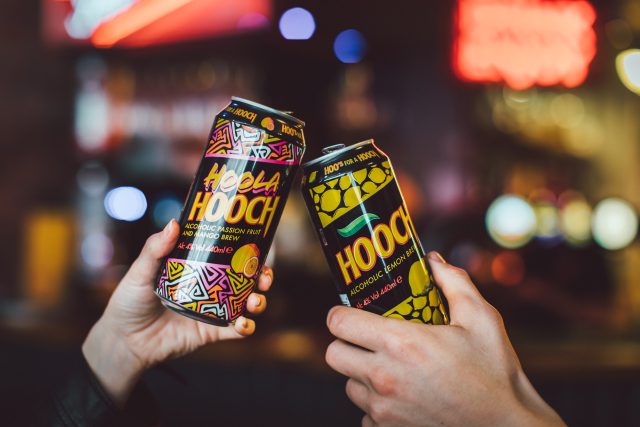Two people cheers Hooch cans: Global Brands Limited acquires Hooch, Hooper’s and Reef brands from Molson Coors