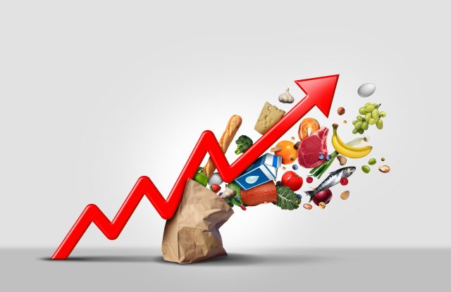 Rising food cost and grocery prices surging costs of supermarket groceries as an inflation financial crisis concept coming out of a paper bag shaped hit by a a finance graph arrow with 3D render elements: Rate of annual inflation slows, but food and drink prices continue to climb