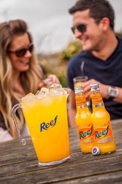 Couple enjoying jug and bottles of Reef: Global Brands Limited acquires Hooch, Hooper’s and Reef brands from Molson Coors