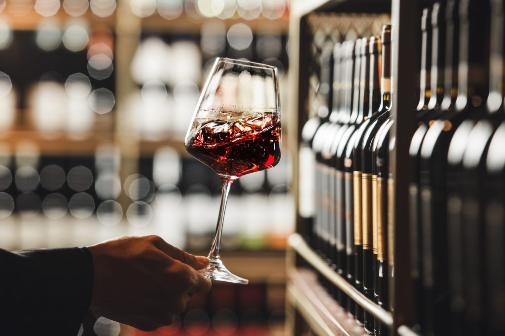 Someone holding a glass of red fine wine