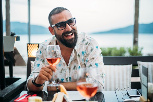Man drinking rose wine at sunset