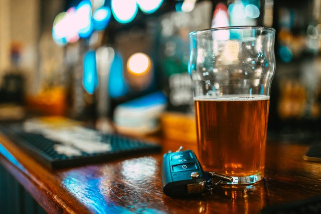 Image: Close up image depicting a partially consumed pint of beer next to a set of car keys on the bar counter, illustrating a drunk driving concepts. Room for copy space. The UK Government is considering slashing the drink-driving limit in England and Wales to match Scotland’s stricter laws. The proposed move could profoundly affect driver behaviour, public safety and the hospitality industry’s bottom line.